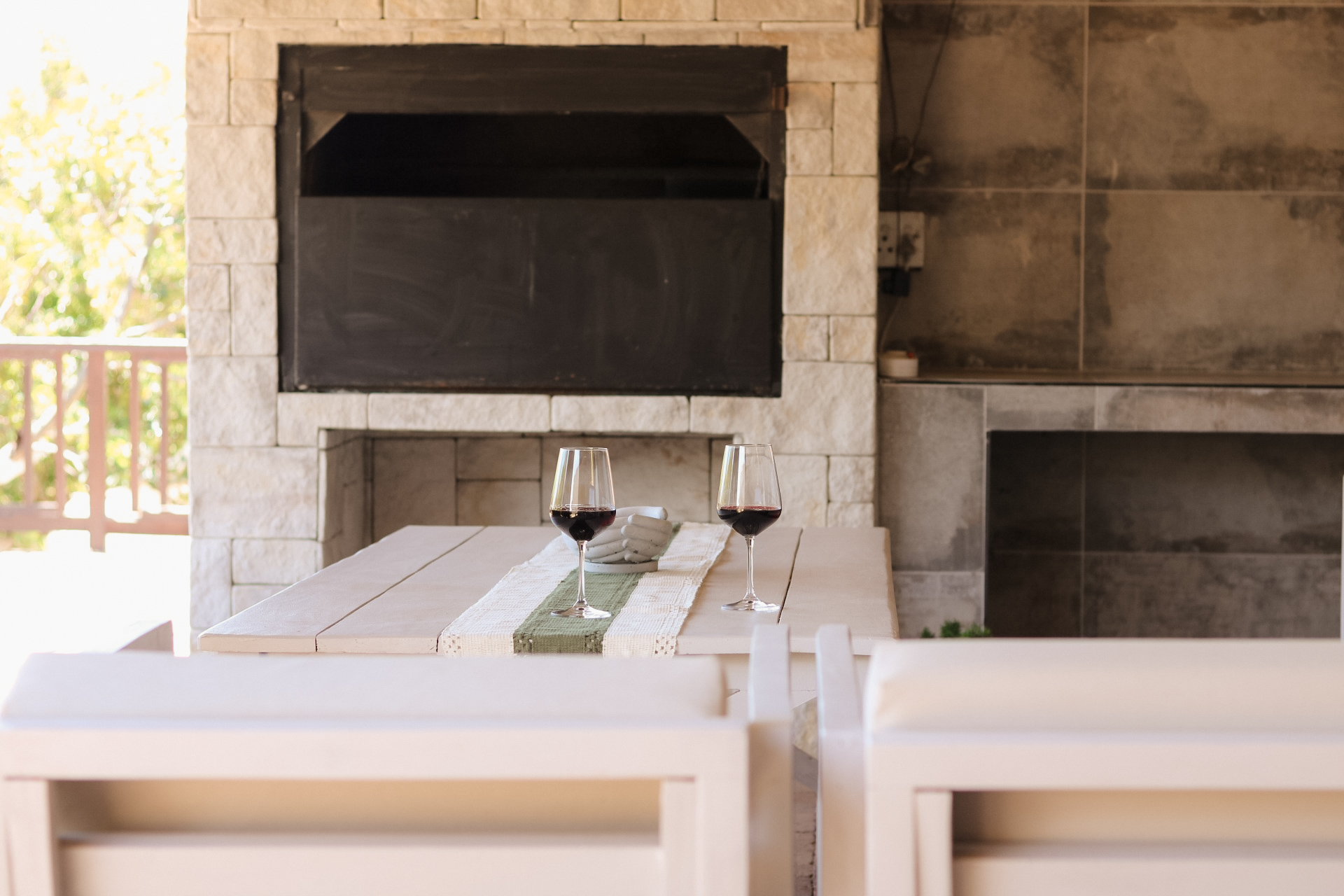 Wine glasses and a table set beside the braai at Rissie’s, ready for a relaxed holiday